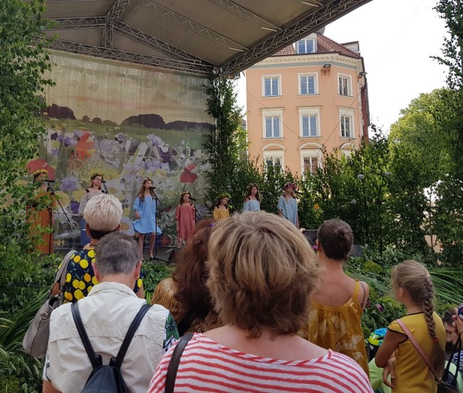 Children singing on stage at a Midsummer celebration